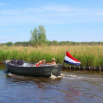 Couple,Is,Sailing,At,River,In,Motor,Sloop,Boat,With